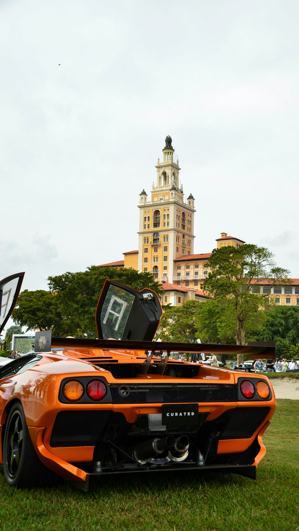 an orange sports car parked in the grass