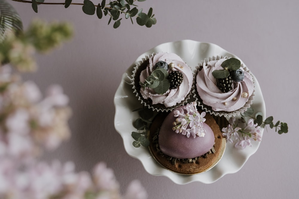 a plate with cupcakes and flowers on it