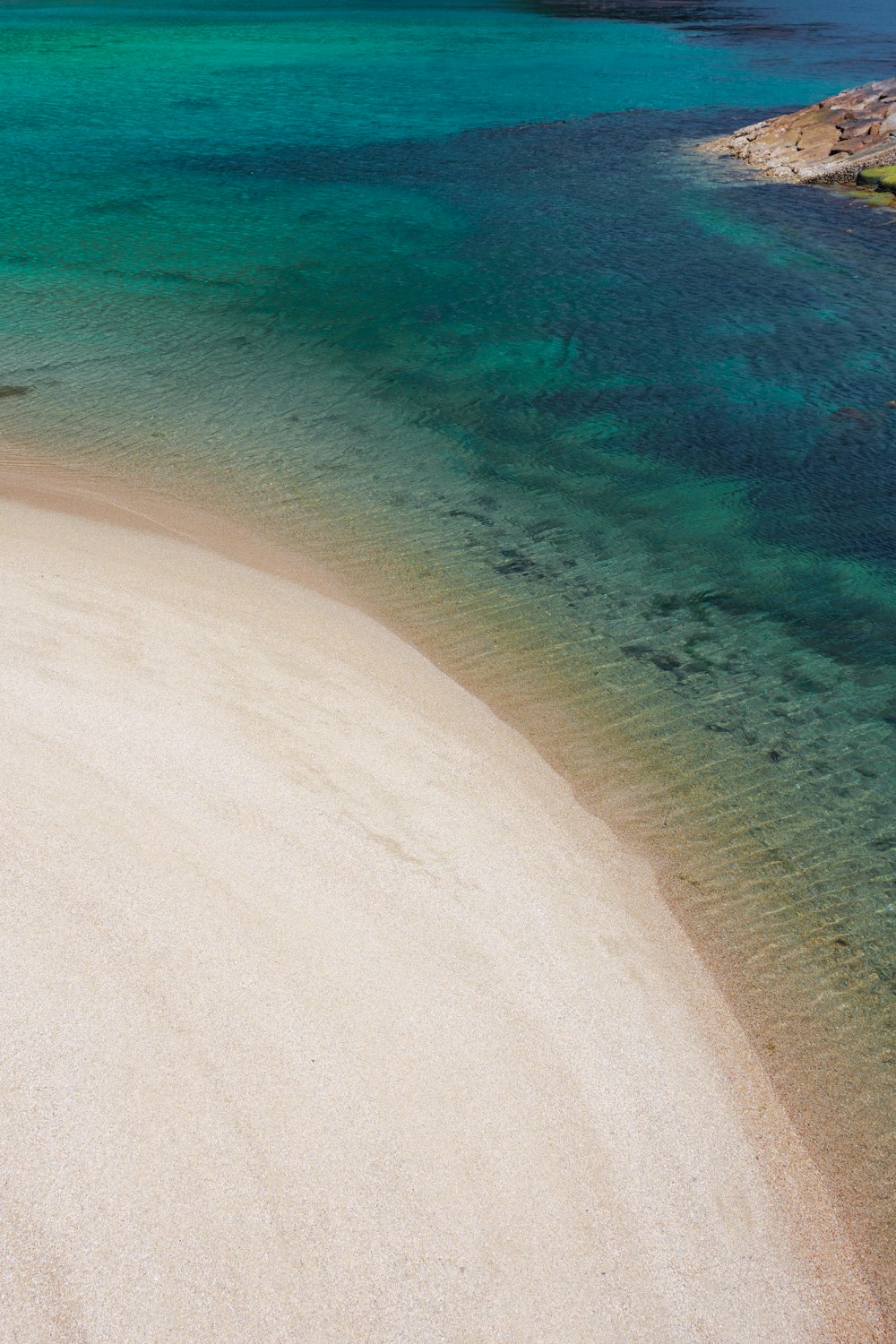 a sandy beach next to a body of water