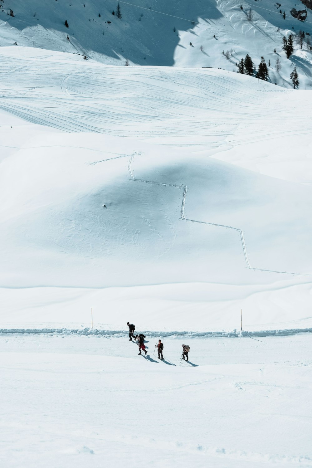 a group of people riding skis down a snow covered slope