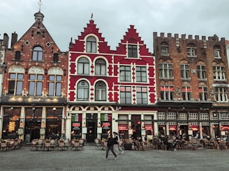 a group of people walking past a red and white building