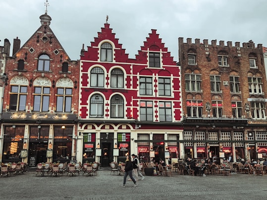 a group of people walking past a red and white building