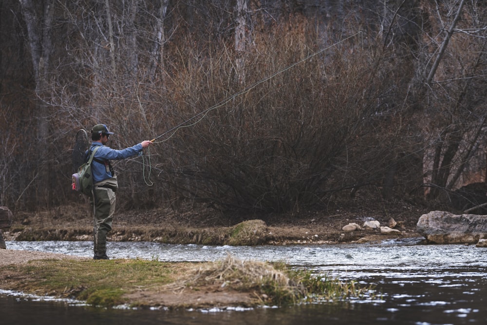 Un homme fait voler un poisson dans une rivière
