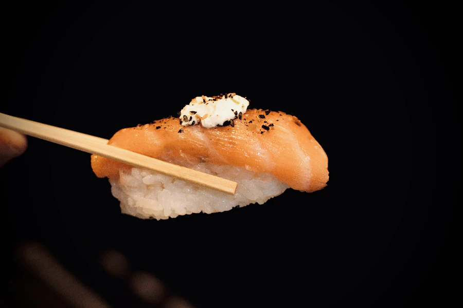 Tamu mengangkat sushi segar dengan sumpit