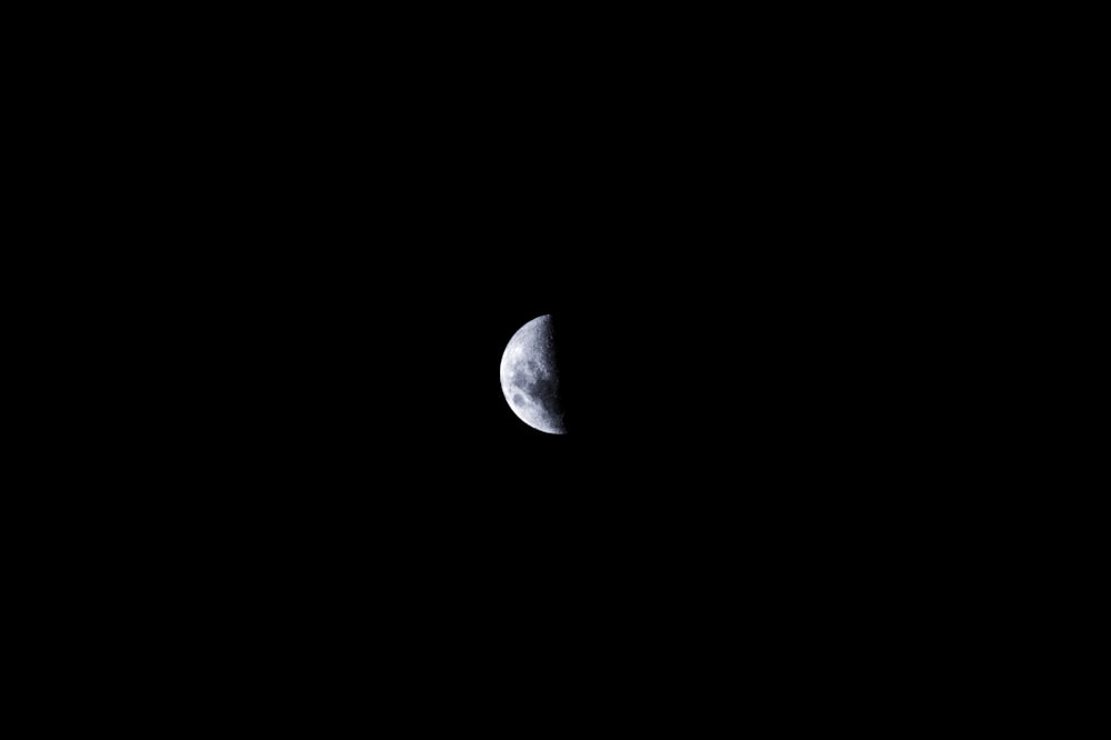 a half moon in the dark sky with a black background