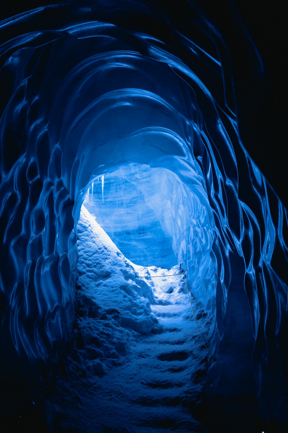 a tunnel in the ice with snow on the ground