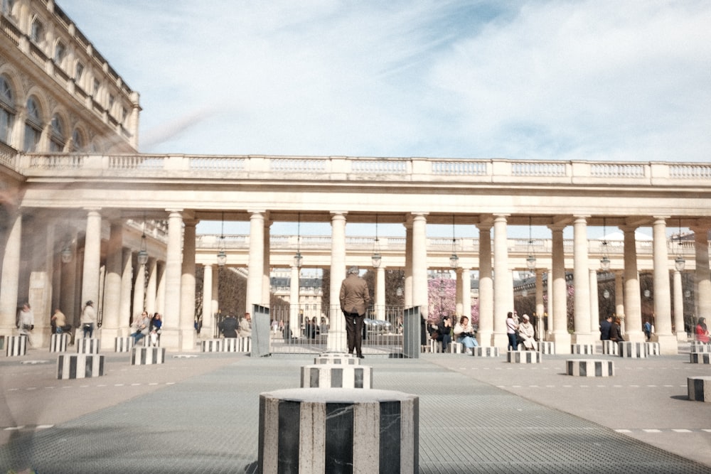 Un gran edificio con columnas y gente caminando a su alrededor