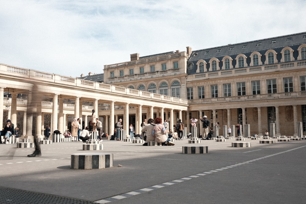 a group of people sitting and standing around a courtyard