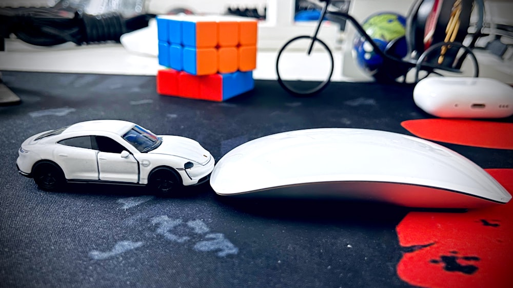 a toy car sitting next to a computer mouse