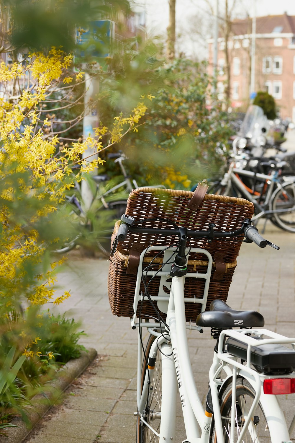 a bicycle with a basket parked on a sidewalk