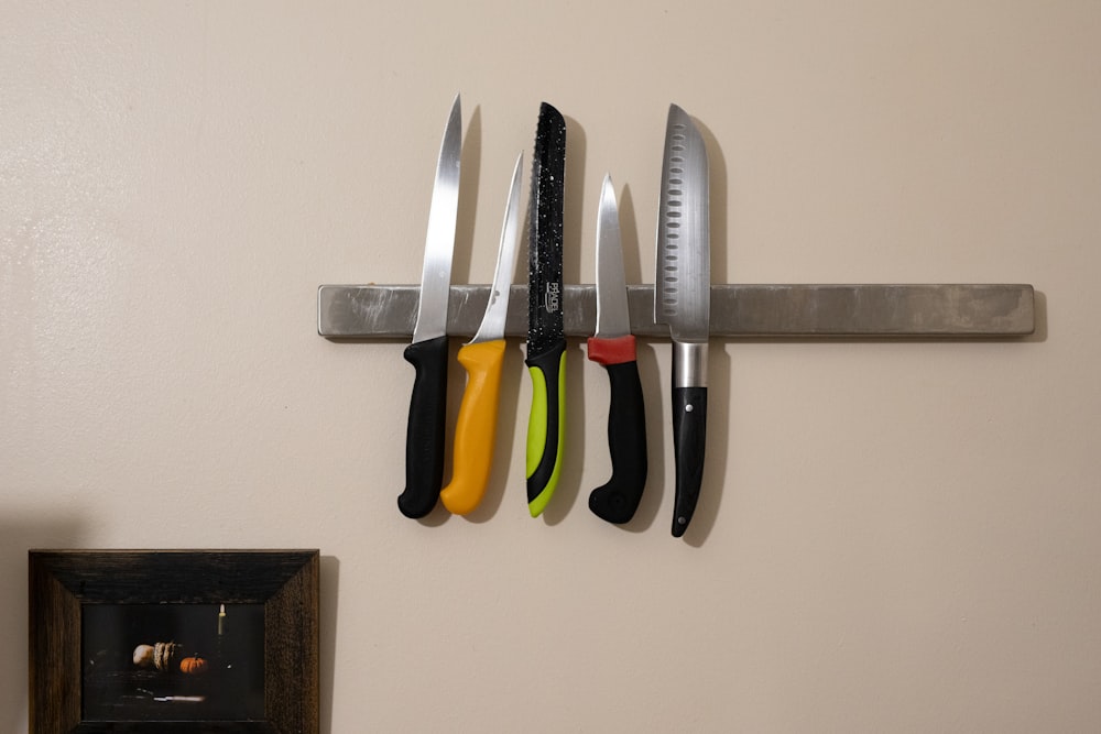 a wall mounted knife rack with knives on it