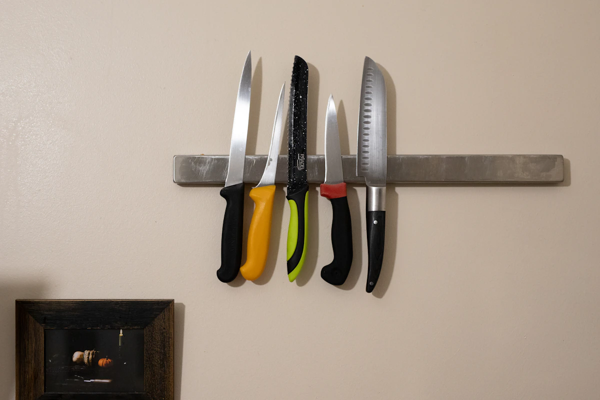 Magnetic strip holding knives on a small kitchen wall