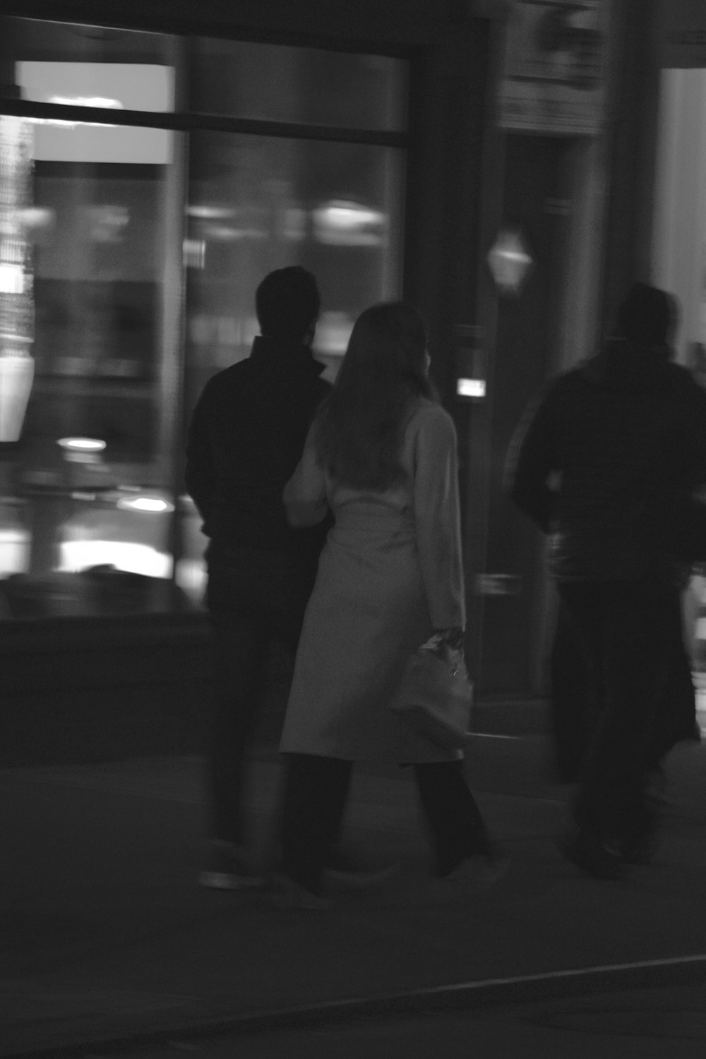 a group of people walking down a street at night