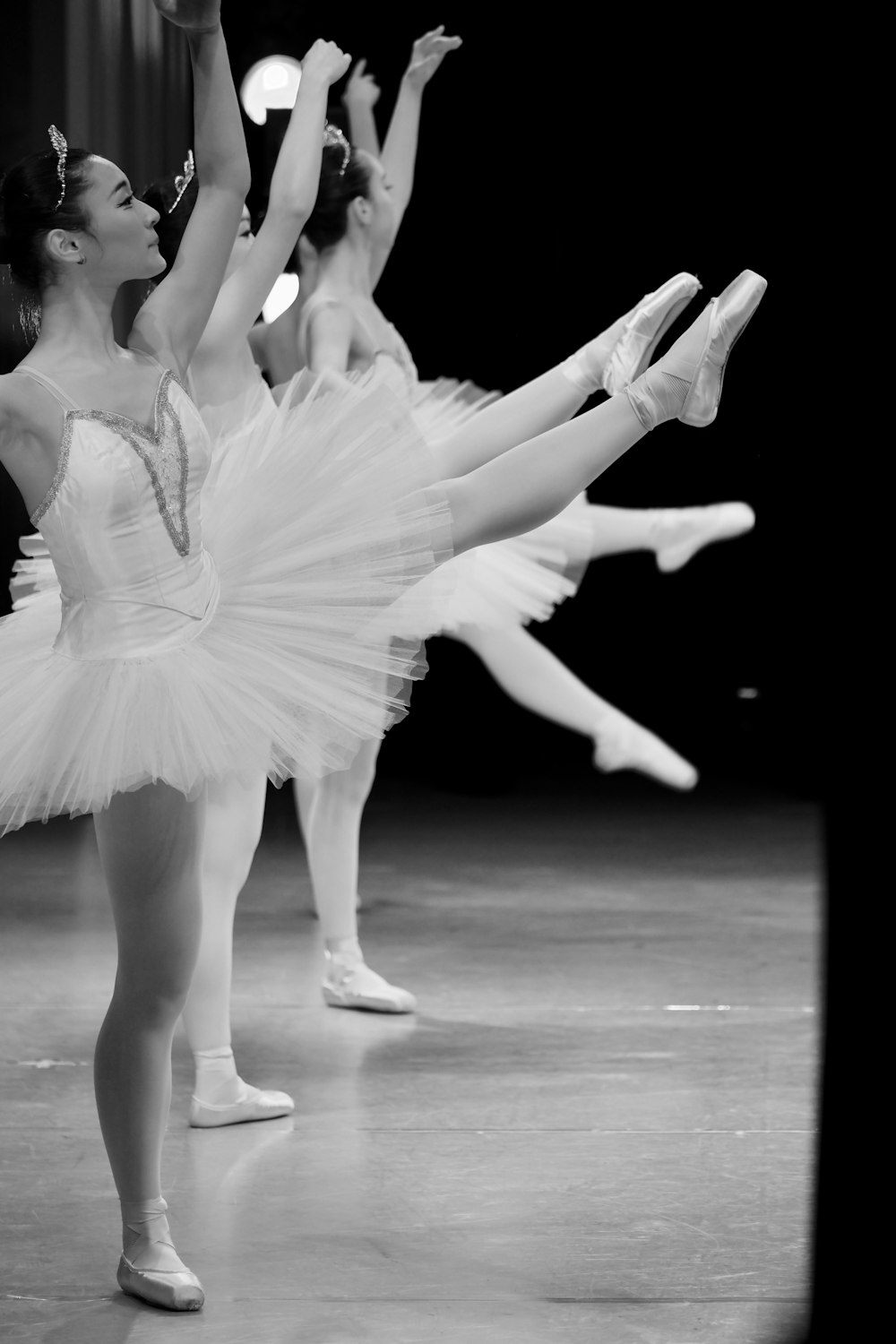 a black and white photo of three ballerinas