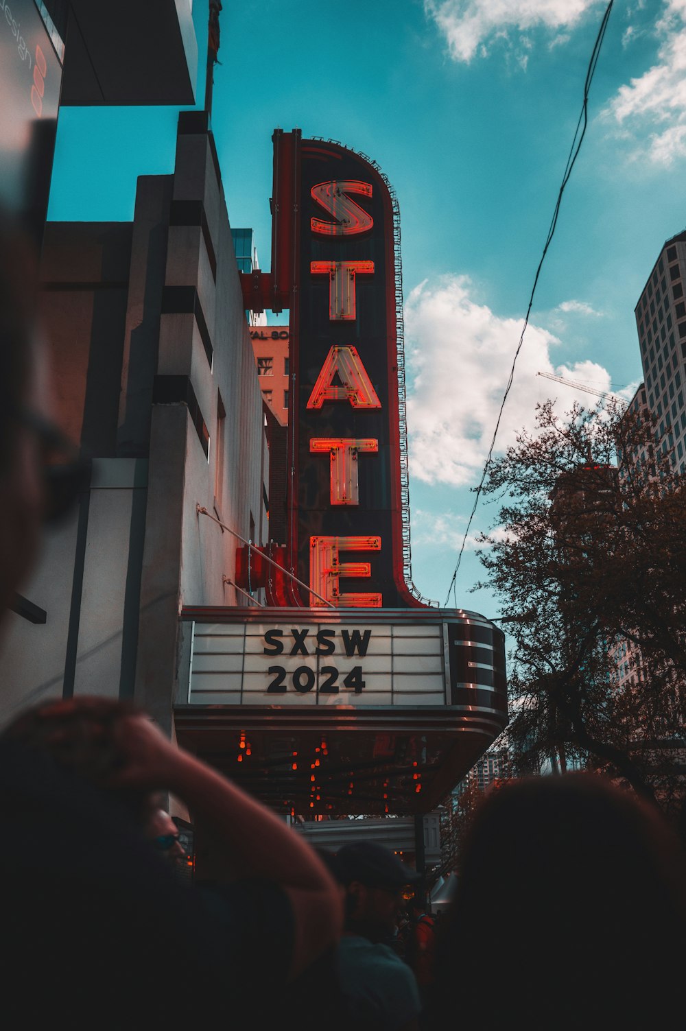 a crowd of people standing outside of a theater