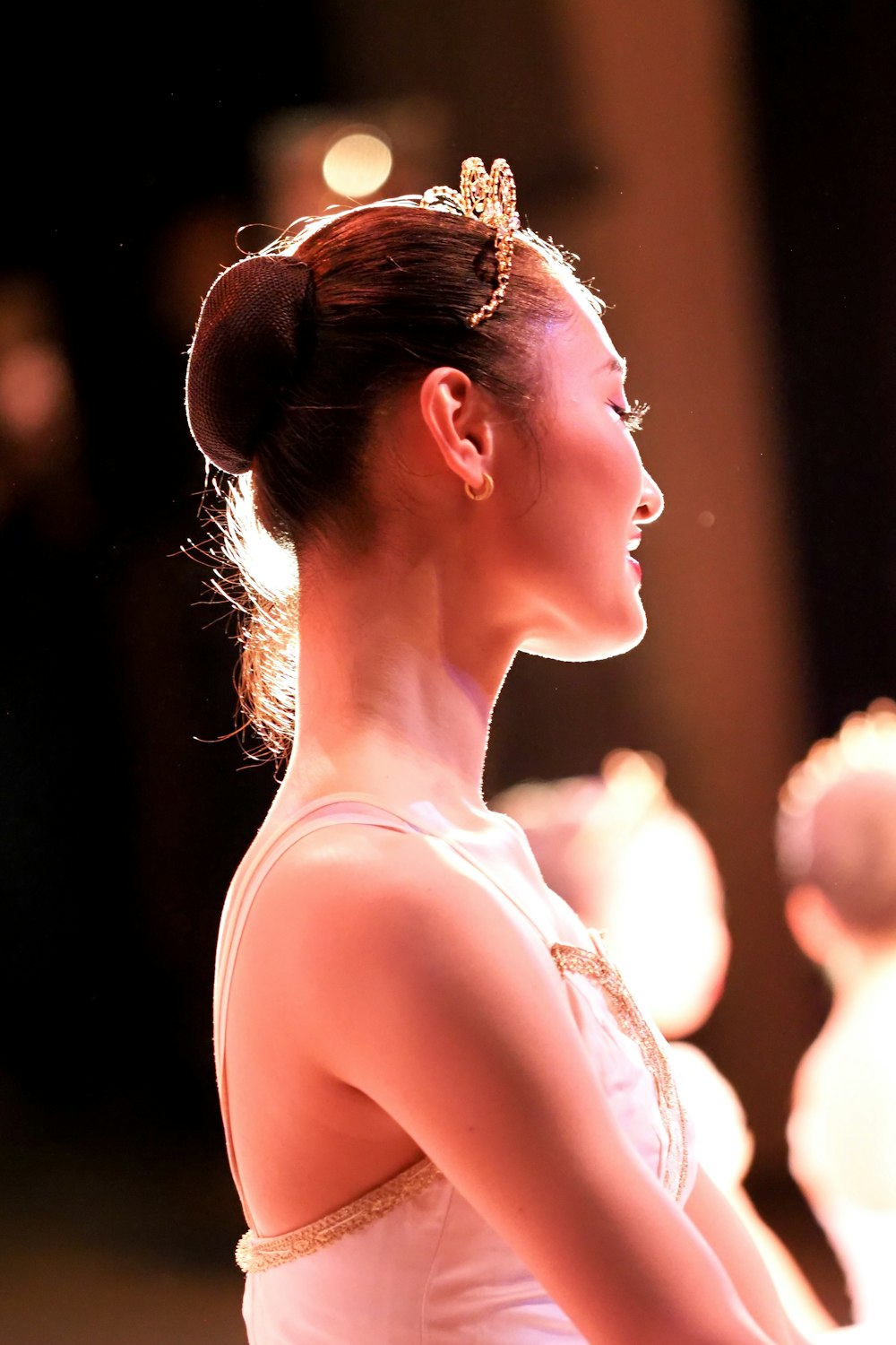 a woman in a white dress is looking away from the camera