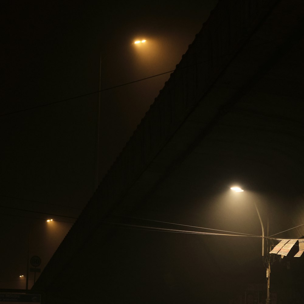 a street light shines in the dark on a foggy night