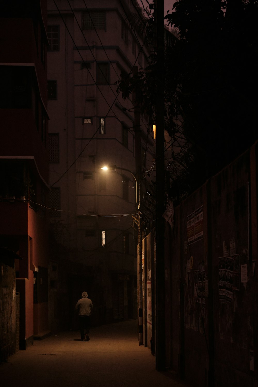 a person walking down a dark alley way at night