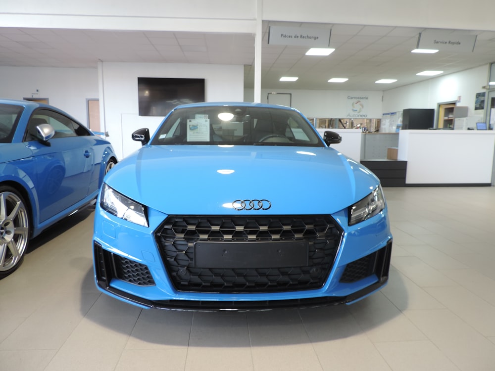 a blue car is parked in a showroom