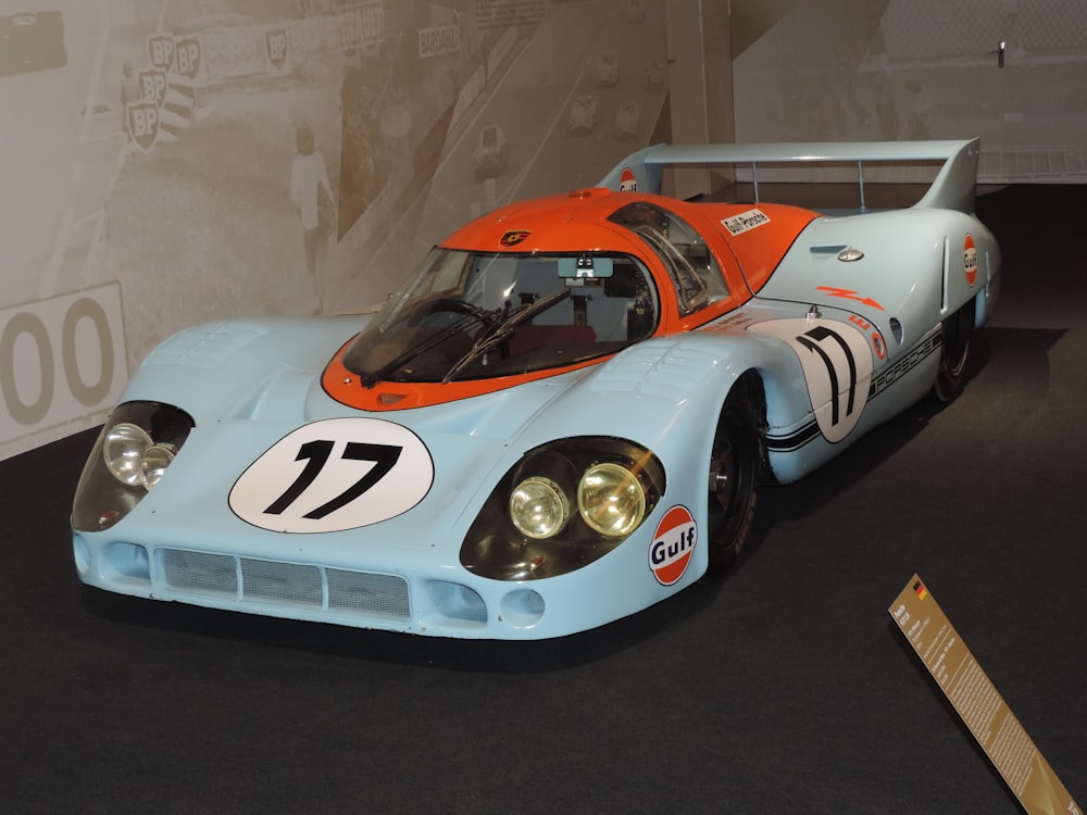 Un coche de carreras azul y naranja en exhibición en un museo