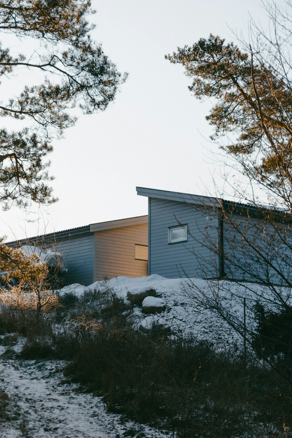 une maison assise au sommet d’une colline enneigée