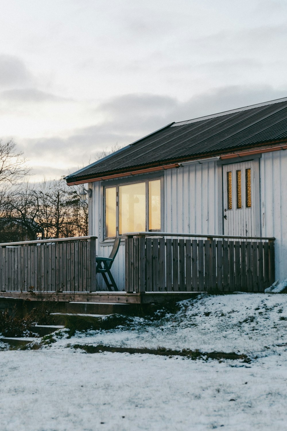 a small white house with a porch and a deck