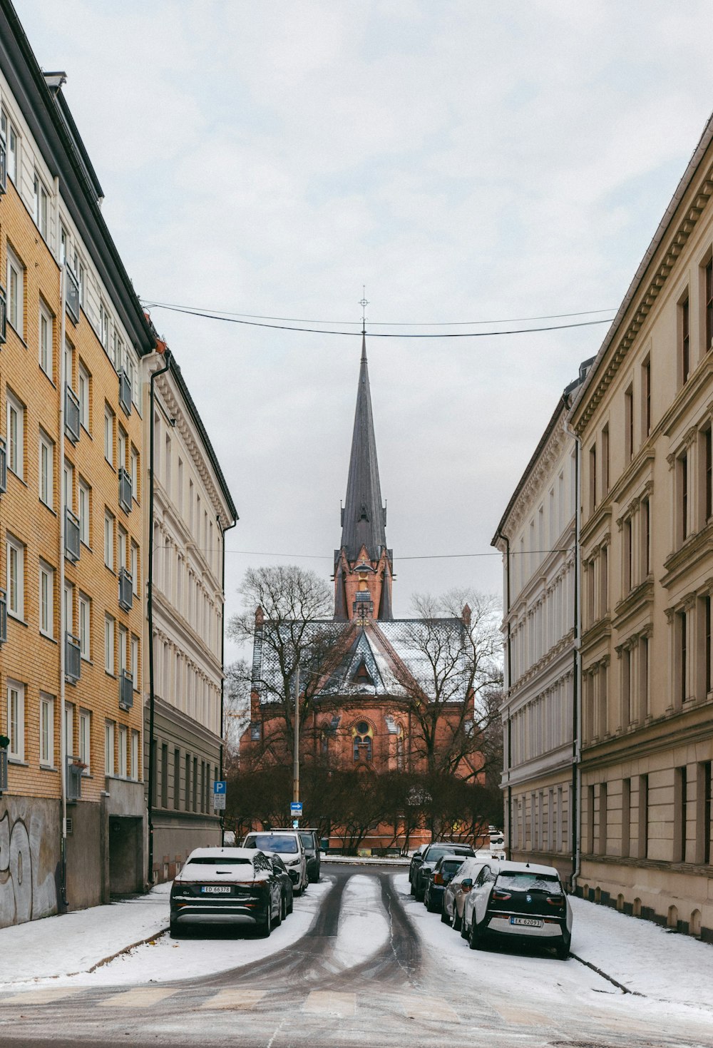 a street with cars parked in front of a church