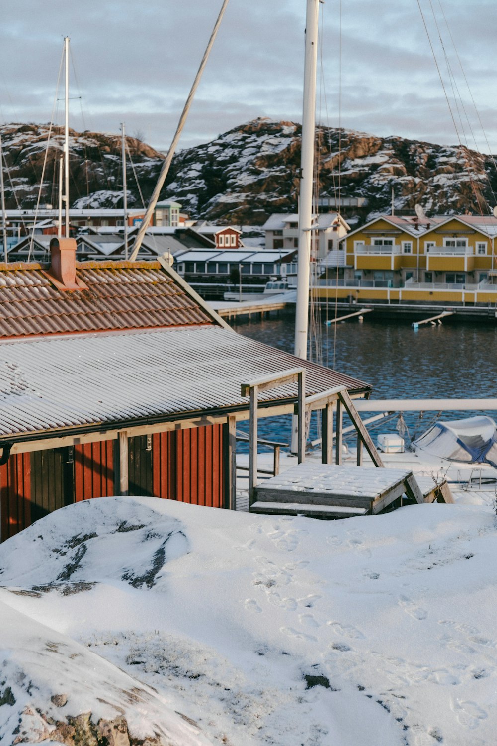 a boat is docked in a harbor with snow on the ground