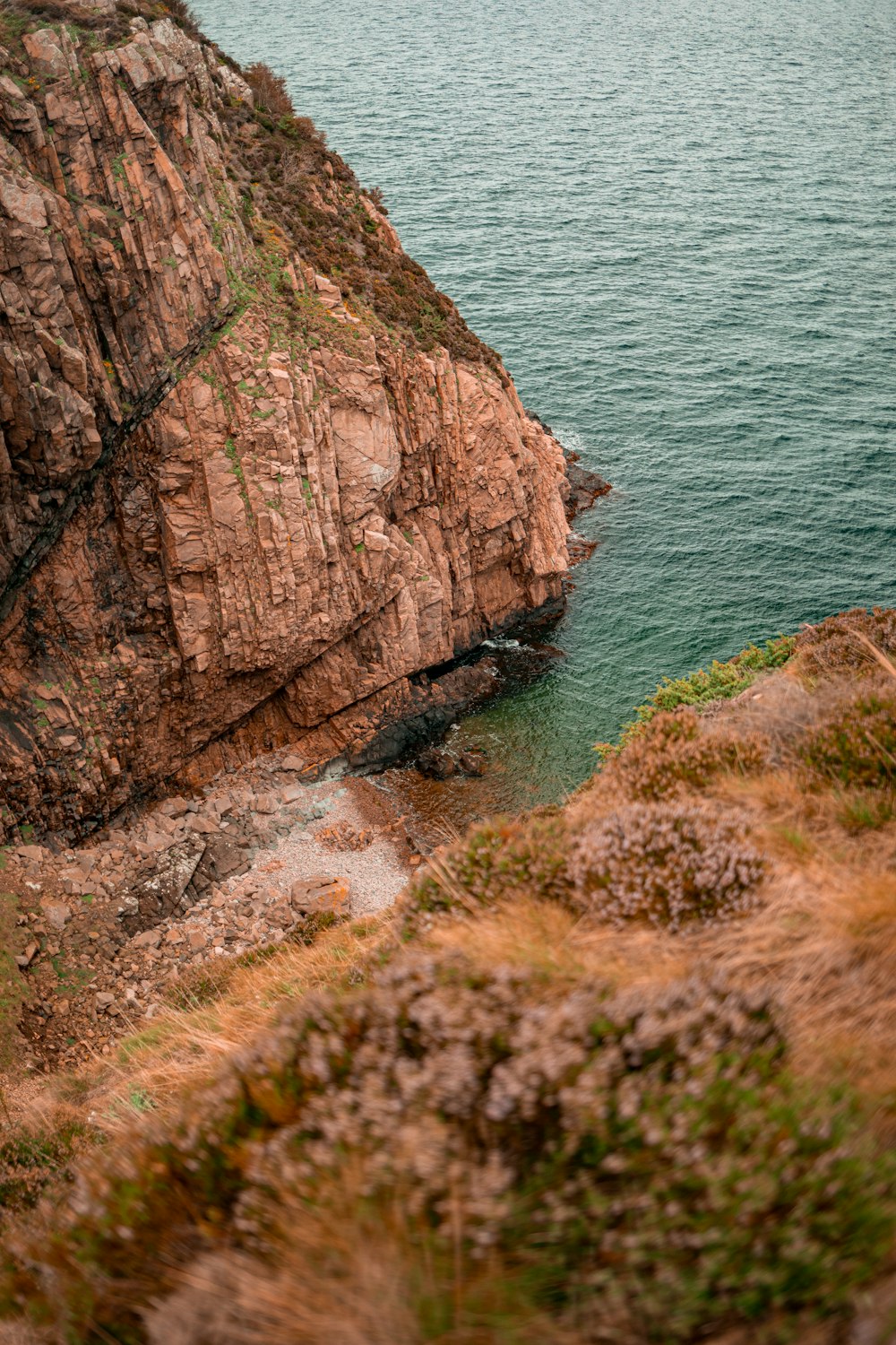 a person standing on a cliff above the water