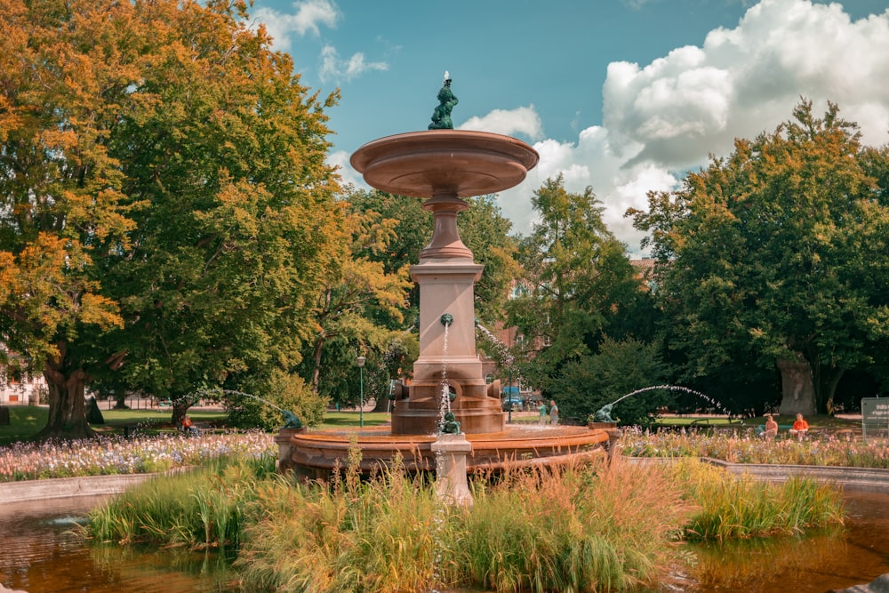 a fountain with a statue on top of it in a park