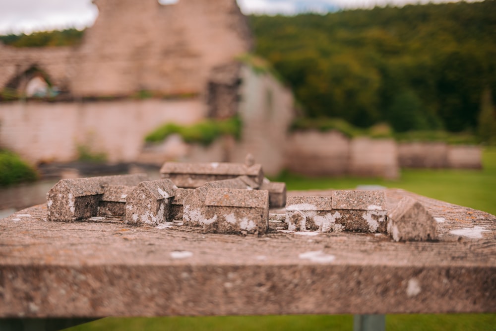 a close up of a bench with a building in the background