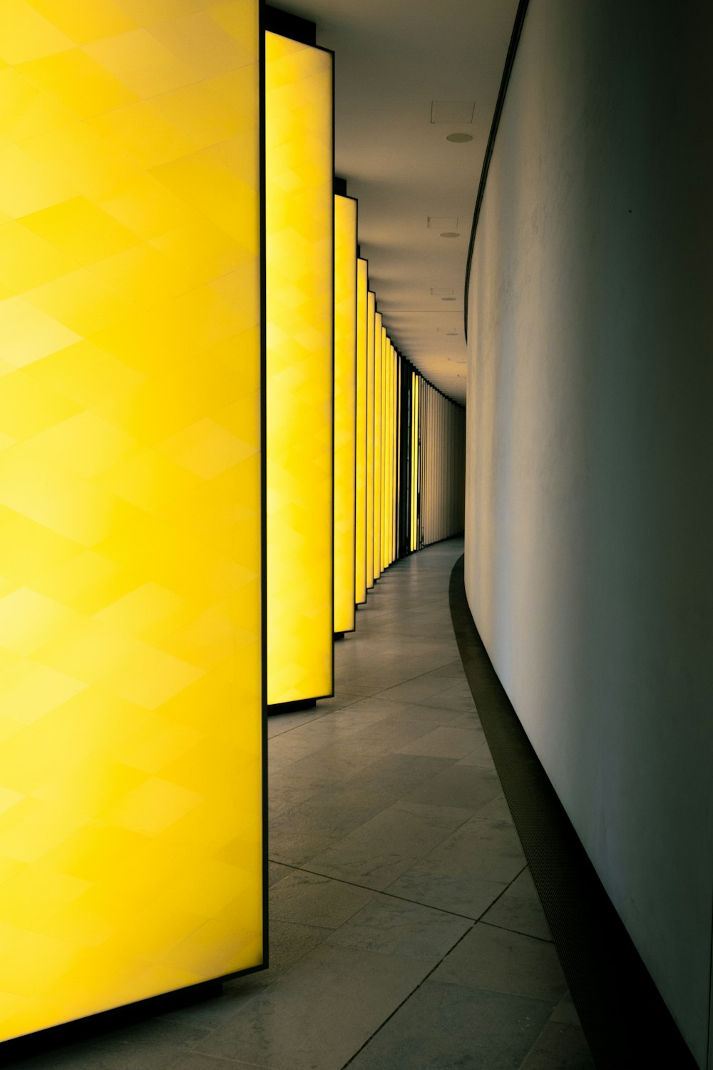 a long hallway lined with yellow lights next to each other