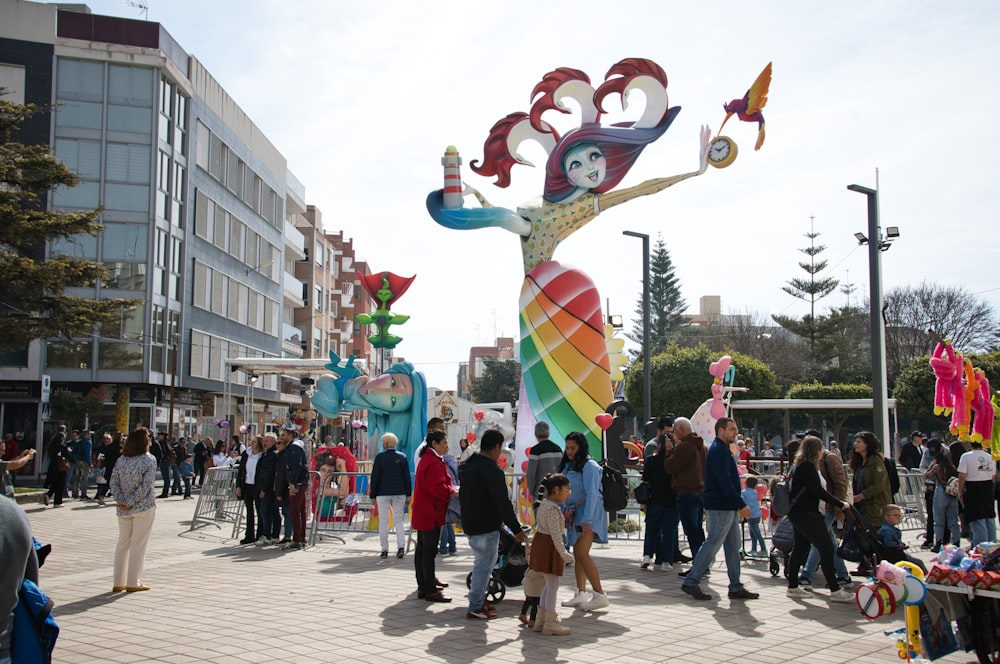 a group of people standing around a colorful statue