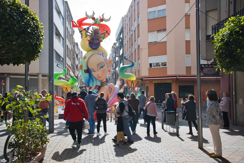 a group of people walking down a street next to tall buildings