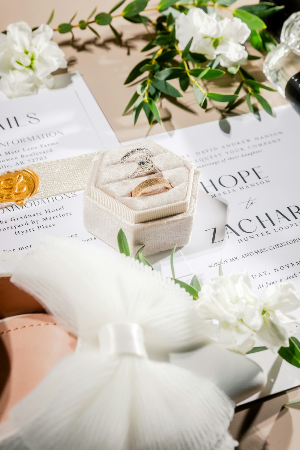 a wedding ring sits in a box next to a pair of shoes