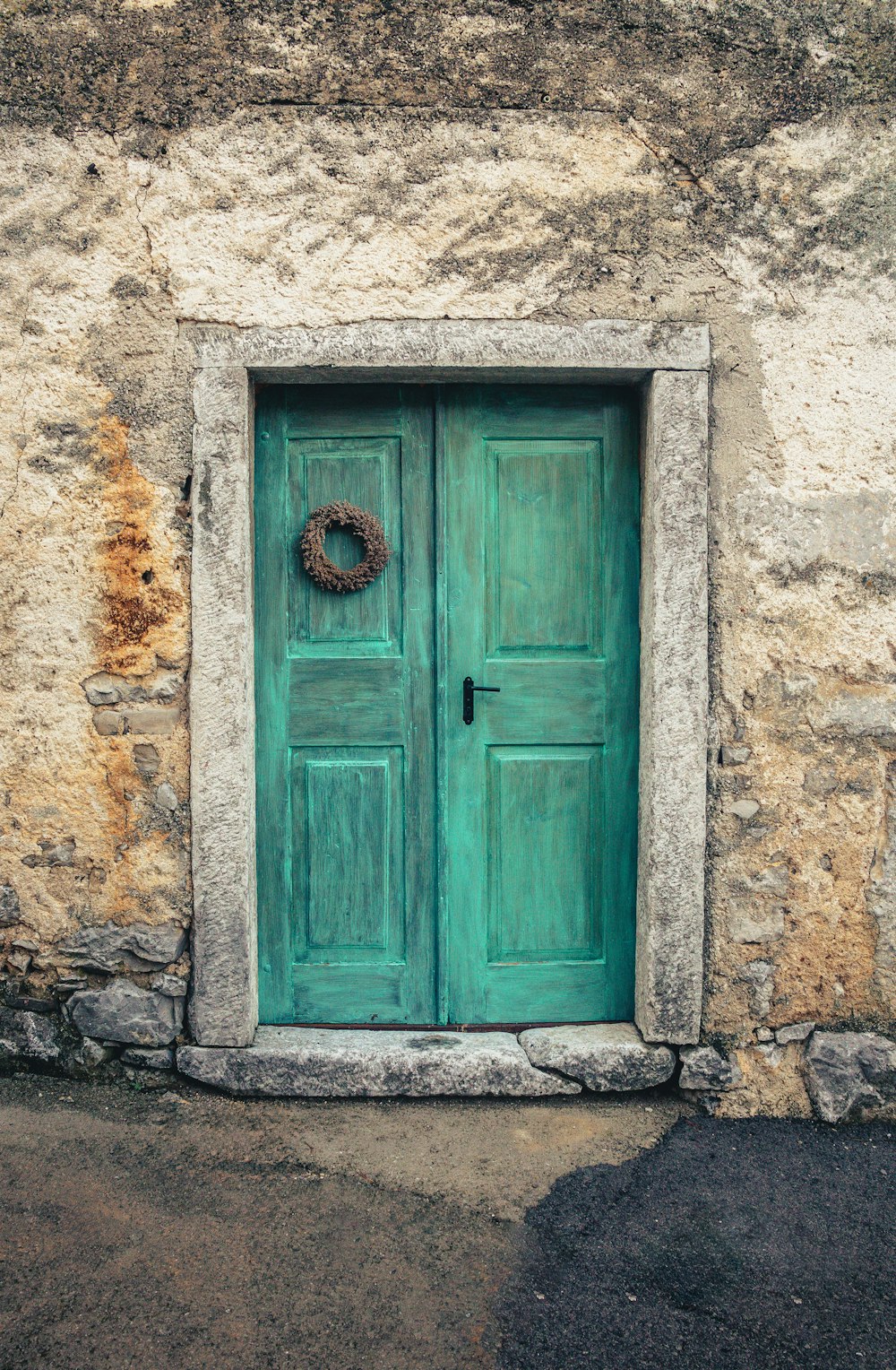 a green door with a wreath on it