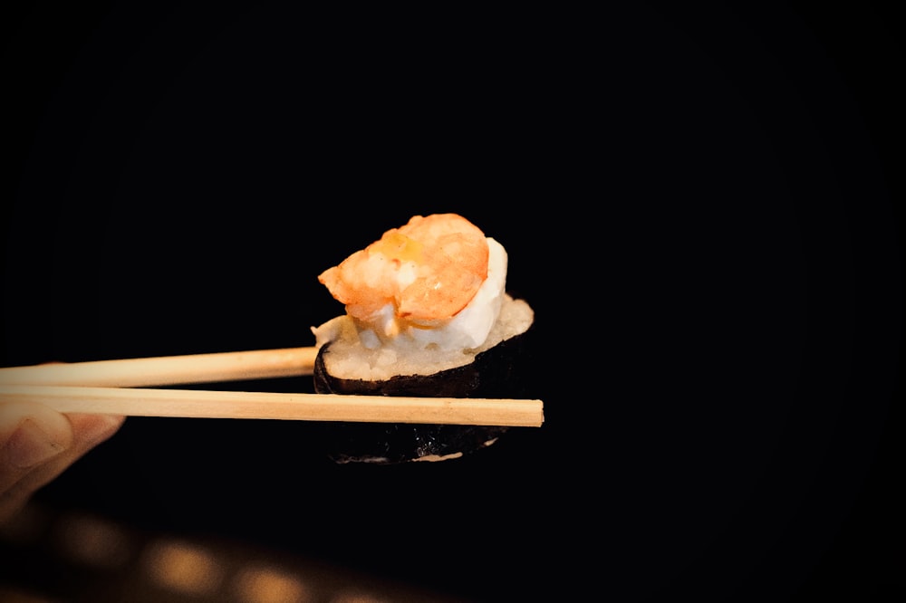 a person holding chopsticks with food on them