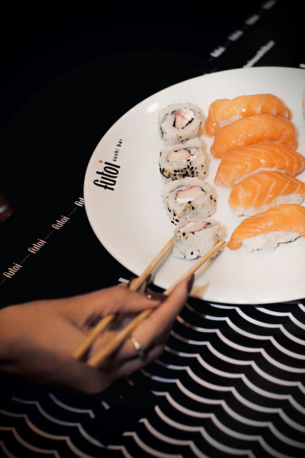 a plate of sushi and chopsticks on a table