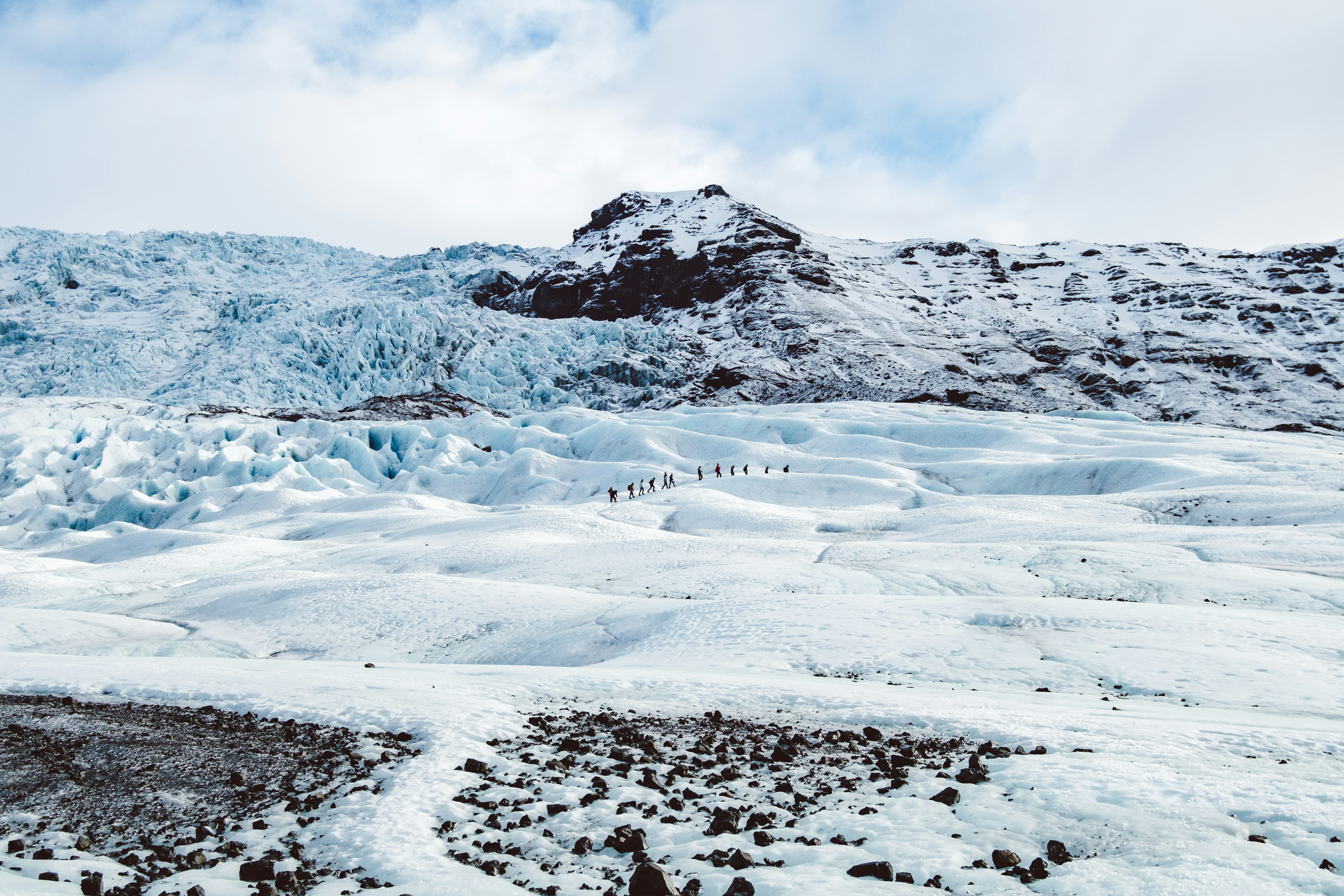 a group of people walking across a snow covered field, 