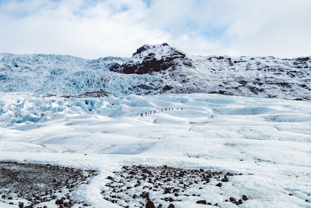 a group of people walking across a snow covered field