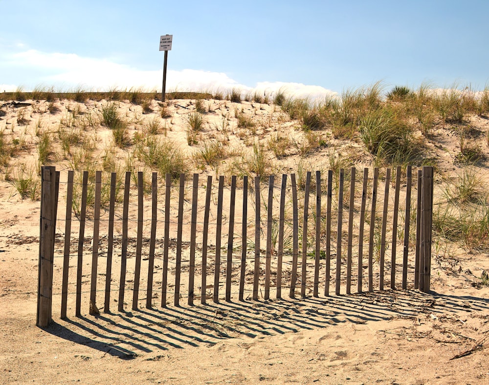 a fence made out of sticks in the sand
