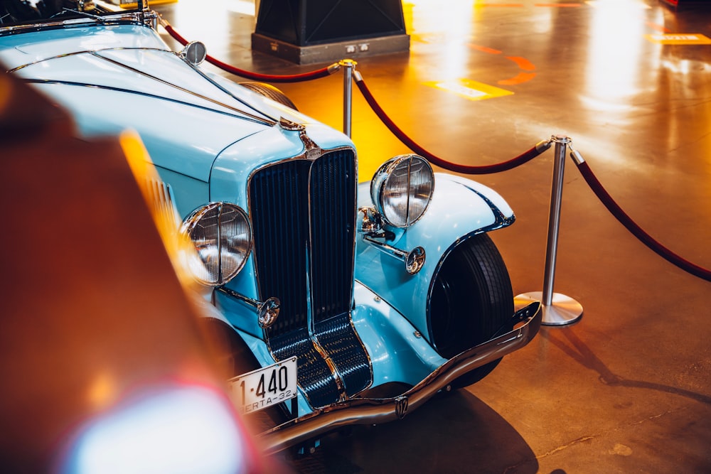 an old blue car is on display at a museum