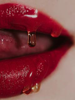 a close up of a woman's lips with a drop of liquid