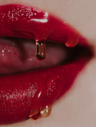 a close up of a woman's lips with a drop of liquid