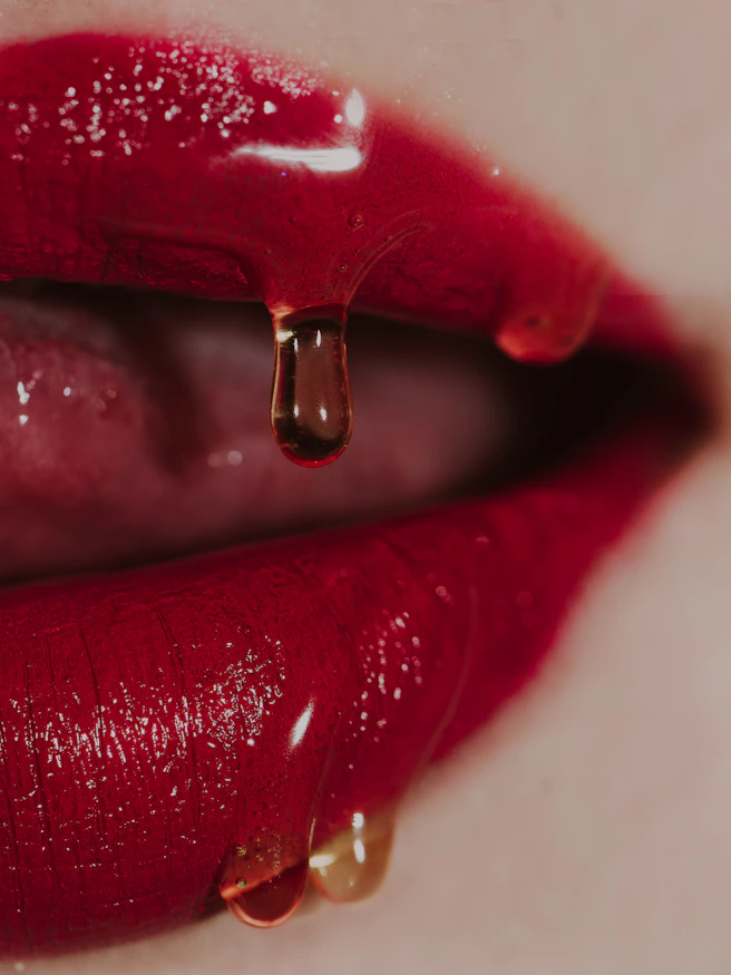 a close up of a woman's lips with a drop of liquid