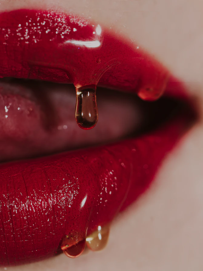 a close up of a woman's lips with a drop of liquid