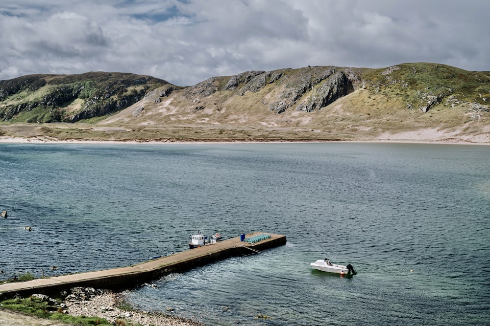 a body of water surrounded by mountains and a dock