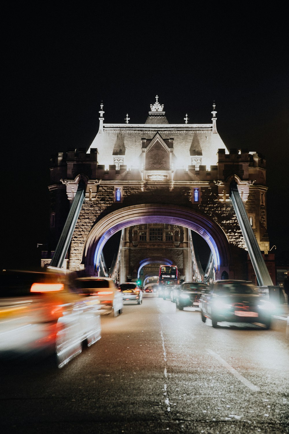 cars driving under a bridge at night time