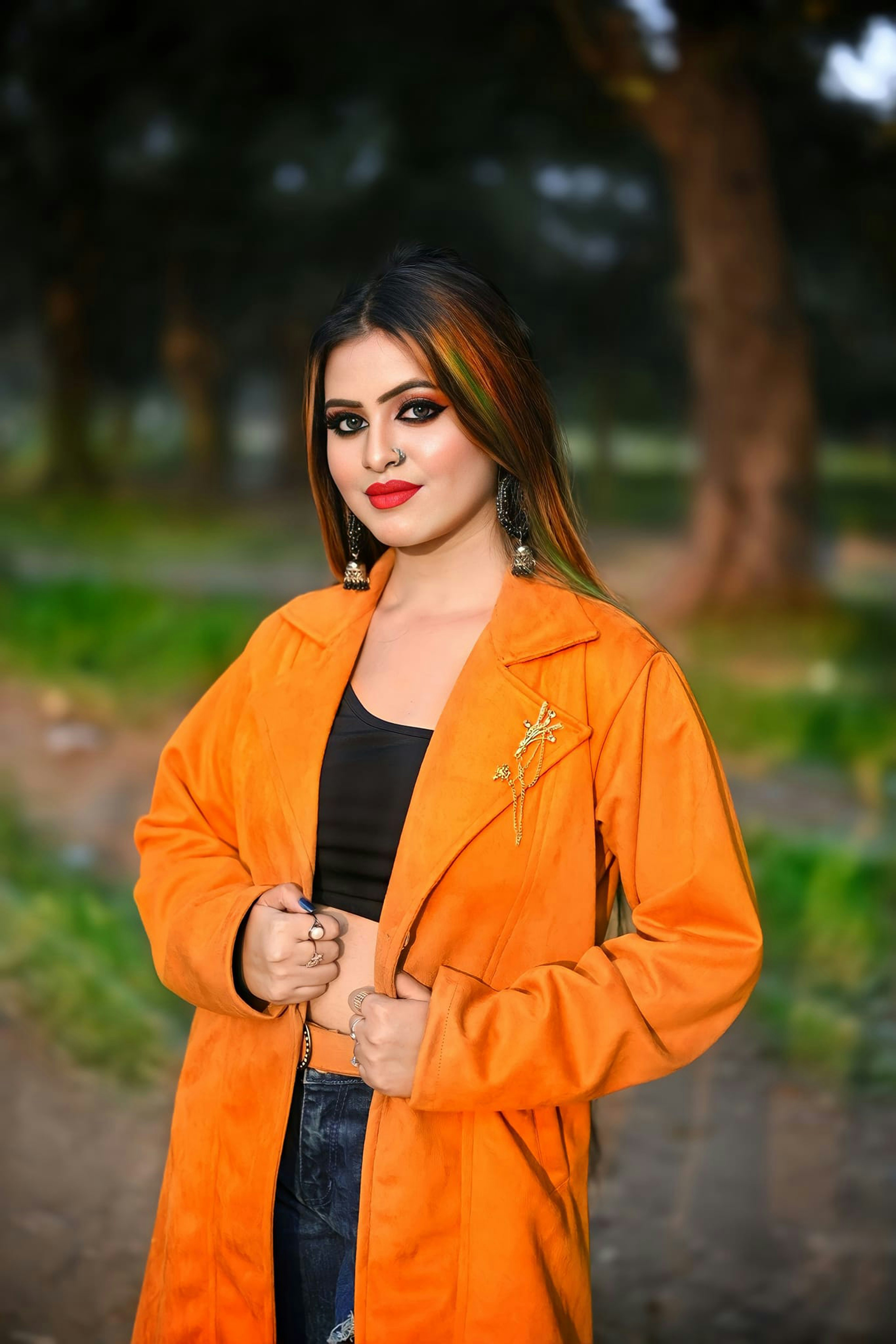 Une femme en veste orange posant pour une photo