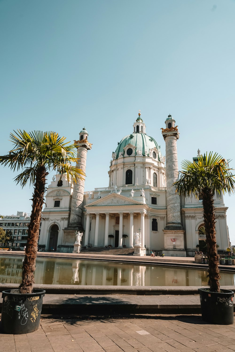 a large white building with two palm trees in front of it